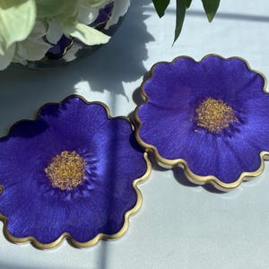A Pair of Elegant Floral Resin Coasters in a Rich Purple Accented with Gold Leaf Flakes Edged in a Gold Leafing
